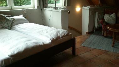 Ferienhaus BUTEN - offener Schlafraum mit Doppelbett und Sitzgruppe