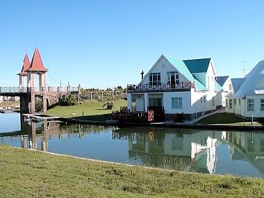 Hausansicht mit Bootsdeck und Terrassen am Kanal