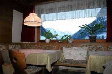 Aufenthaltsraum mit vielen Fenstern und Blick auf die Berge