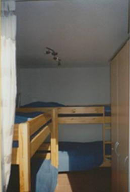 Vierbettzimmer mit Kleiderschrank und Zugang zu kleinem Balkon