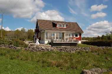 Blick auf Haus mit Wintergarten, Terrasse und Grillplatz