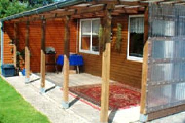 Blockhtte mit Terrasse hinterm Haus im grossen Garten