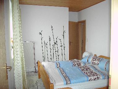 Schlafzimmer mit begehbaren Kleiderschrank und Zugang zum Zimmer 