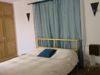 Schlafzimmer mit Ehebett und Zugang zum Patio