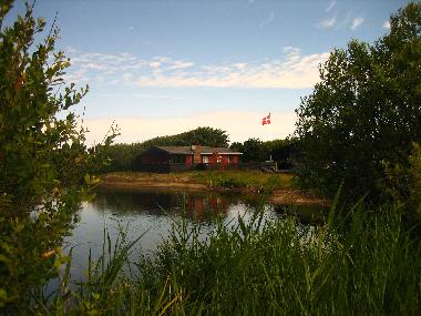 Blick auf Teich mit dem Haus im Hintergrund