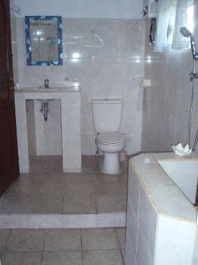 Badezimmer mit 2 Duschen, 2 Waschbecken und einem balinesischen Mandi