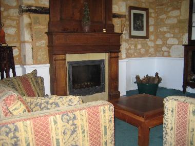 Wohnraum mit historischem Kamin und gemuetlicher Sitzgruppe davor