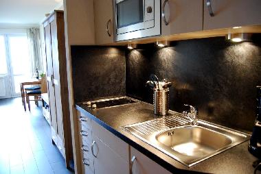 moderne Markenküche mit Lackoberfläche, Mikrowelle, Cerakochfeld und Kühlschrank mit *** Gefrierf