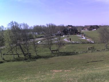 Minigolf mit Reethaus am Meer im Hintergrund