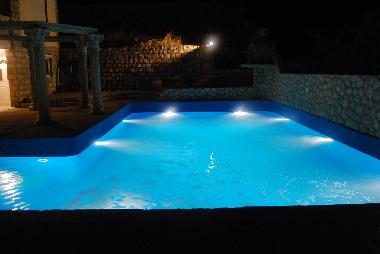 Ein sehr gro�er,nachts beleuchteter Pool erwartet Sie
