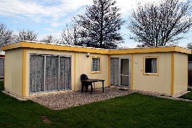 Aussenansicht mit Terasse,Gartensthle,Tisch und Garten.