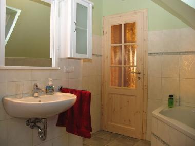 Oberes Bad mit Eckbadewanne, Spiegelschrank, Waschbecken, WC und Waschmaschine