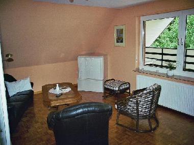 Das Wohnzimmer mit Blick auf den groen, teilweise berdachten Balkon.