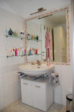 Badezimmer mit groem Wandspiegel und viel Ablageflche