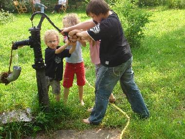 gro�e Kinder an der Schwengelpumpe...