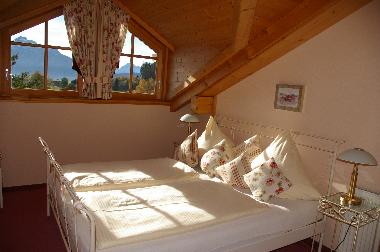 Schlafzimmer in Wohnung Aggenstein mit Blick auf die Alpen