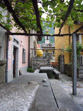 Pergola mit Granittisch vor dem Haus