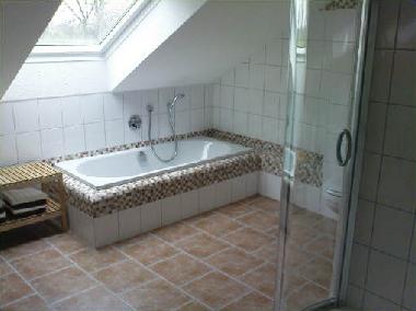 Badezimmer mit Dusche, Badewanne und Waschmaschine