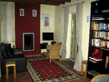 Wohnzimmer mit Ledersofa, Kamin, Bcherregal. Fenstertr ffnet zu einer Terrasse