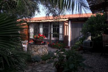 Garten mit Blick auf Terrasse (rechts) und Wintergarten