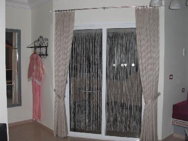 Eingangsbereich Studio mit Blick zum m�blierten Balkon mit Liegestuhl