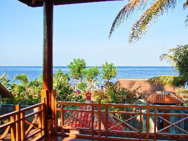 Balkon mit Blick aufs Meer und Strand und eine bunte balinesische religi�se Zeremonie.