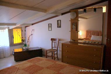 Schlafzimmer mit Spiegelkommode und Einbauschrank.