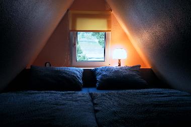 In der Dachgaube eingebautes Doppelbett mit Blick auf den Rhein.