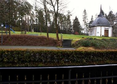 Blick vom Balkon auf Spielplatz, Wald undubertuskapelle