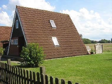 das Ferienhaus von der Seitenansicht. Auf dem gro�en Grundst�ck finden Kinder gen�gend Freiraum zum 