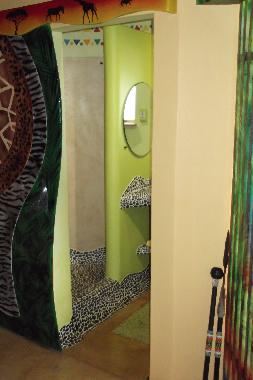 Schiebet�r zum Badezimmer mit Dusche, Waschbecken und Toilette.