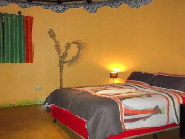 Afrikanischer Schlafraum mit Queensize-Doppelbett.