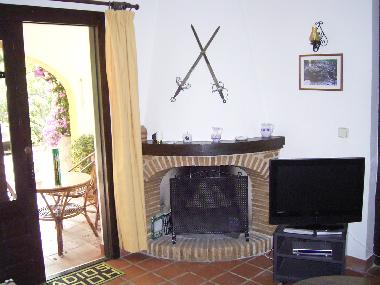 Kaminecke mit TV im Wohnzimmer oben mit Zugang zur Balkon-Terrasse und Pool