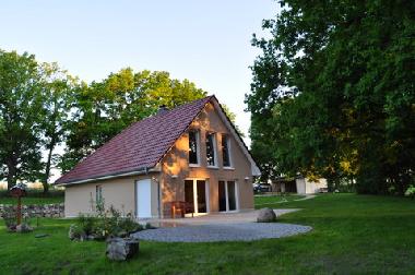 Blick auf das Ferienhaus und die Terrasse, im Hintergrund das Carport und der Eingangsbereich
