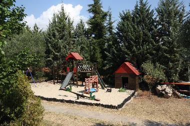 Der Kinderspielplatz mit Klettergerst, Schaukel, Rutsche und mehr  im Sandkasten.