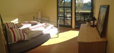 Schlafzimmer mit Balkon und Blick aufs Wasser und Garten