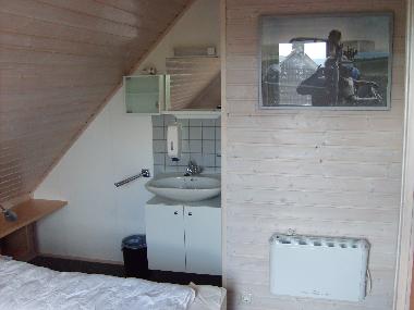 De kleine slaapkamer boven met wastafel