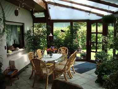 Der Wintergarten mit schnen Rattanmbeln und Schattierung 