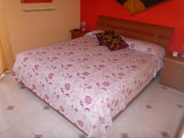 Schlafzimmer mit Doppelbett und Balkon