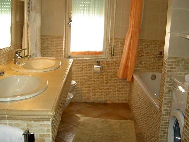 Badezimmer mit Bade und Duschwanne Doppelwaschbecken und Waschmaschine