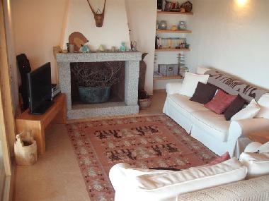 Wohnzimmercouch im 1. Stock mit Kamin, links Veranda