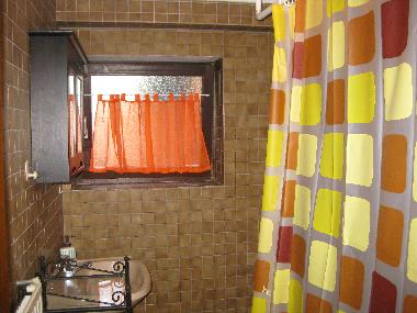 Blick ins erste Badezimmer. In diesem befindet sich neben dem Waschbecken und Toilette eine Badewann