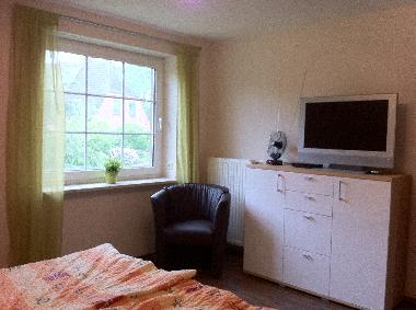 Schlafzimmer 2 im OG mit Doppelbett, Sitzecke und TV