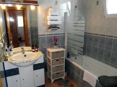 Das Badezimmer mit Badewanne und Duschgelegenheit ist zwischen den Schlafzimmern plaziert.