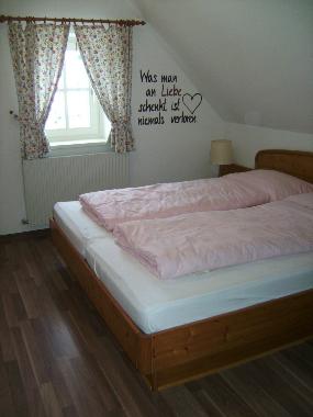 Das Doppelbettzimmer mit Holzmbel und Laminatboden.