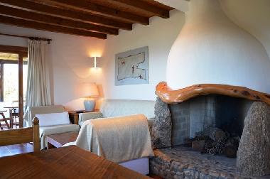 Kamin, Wohnzimmercouch und dahinter Ausgang zur Veranda