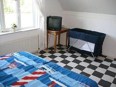 Das Schlafzimmer ist auch mit Kinderbett und TV ausgestattet.