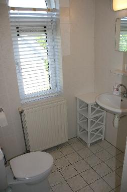 Blick auf das Badezimmer mit WC, Dusche und Waschbecken.