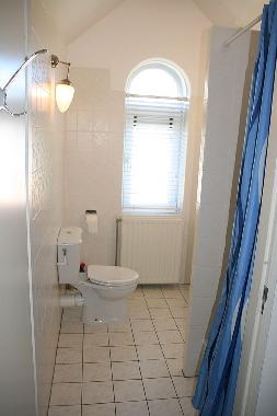 Blick auf das Badezimmer mit WC, Dusche und Waschbecken.