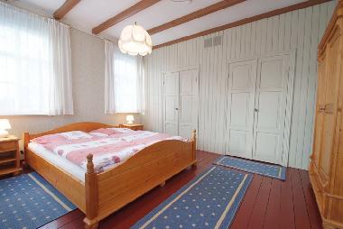 Schlafzimmer mit Doppelbett und zwei Butzenbetten